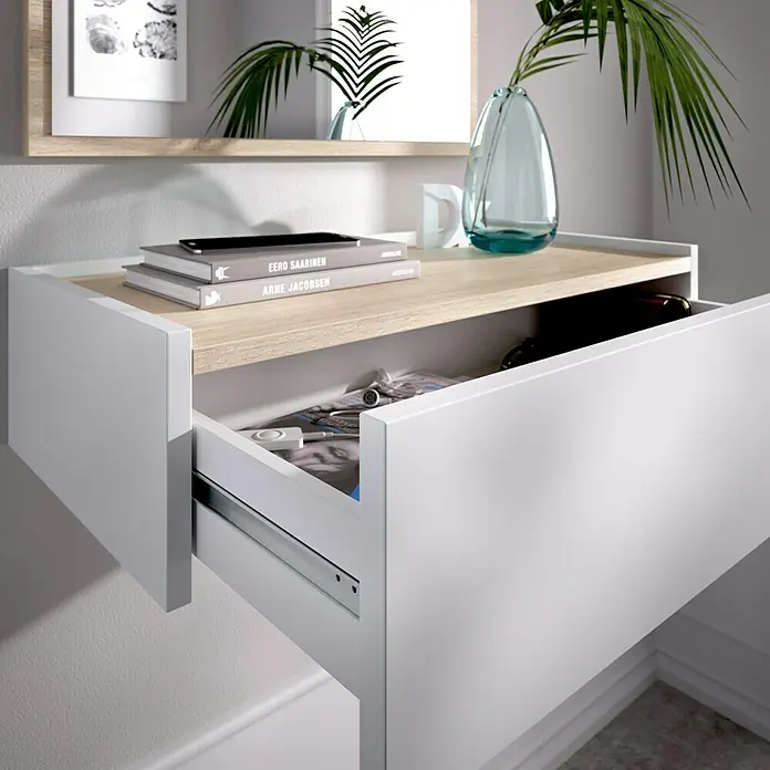 Dekit Mueble para recibidor Ott - Natural/Blanco, Espejo - Consola de pared con cajón en blanco y aspecto de madera, con libros y móvil encima. Al fondo un espejo y un jarrón con planta.