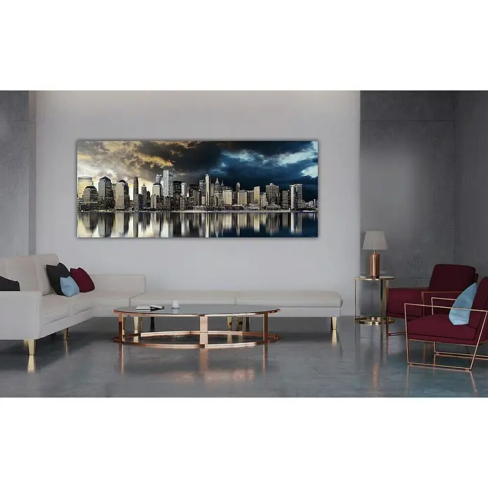 Bild - Gold City, B x H: 150 x 60 cm - Elegantes Wohnzimmer mit einer beeindruckenden Wandkunst, die eine Skyline unter einem dramatischen Himmel zeigt. Die Kunst ist ein Blickfang.