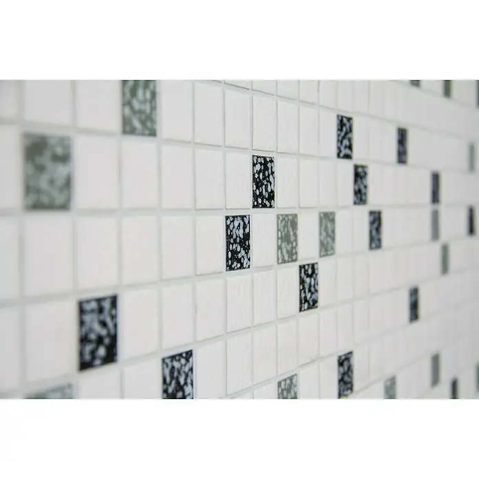 Mosaikfliese Quadrat Mix TD 180N - 30,5 x 30,5 cm, Weiß/Schwarz, Glänzend - Nahaufnahme einer Wand mit weißen Mosaikfliesen und einigen bunten Akzentfliesen, die ein stilvolles Muster ergeben.