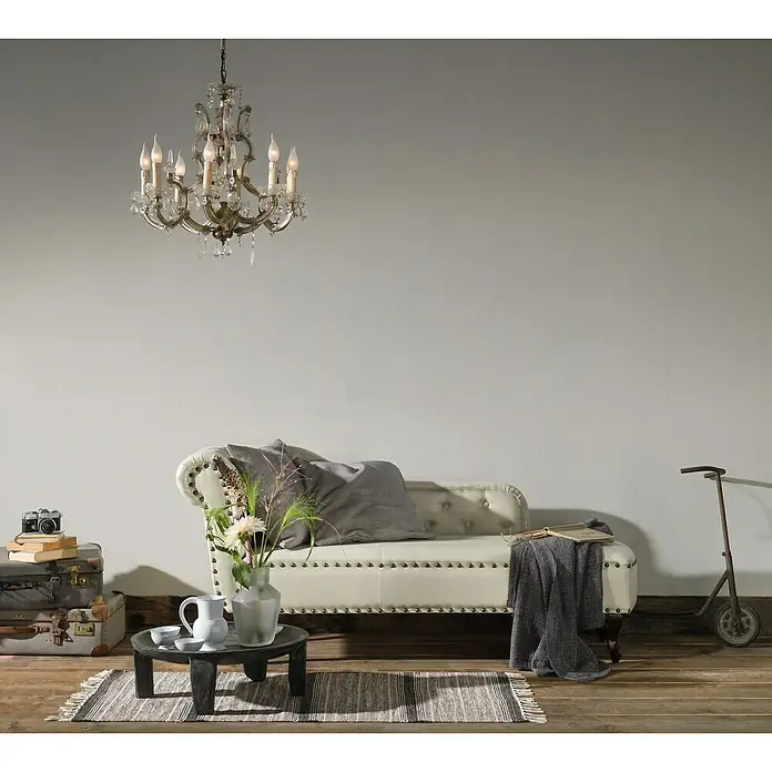 A.S. Création Romantico Vliestapete - Silber, Uni, 10,05 x 0,53 m - Elegantes Wohnzimmer mit einem Kronleuchter, einem Sofa mit Kissen, einem Tisch mit Blumen und einem Teppich für ein gemütliches Ambiente.