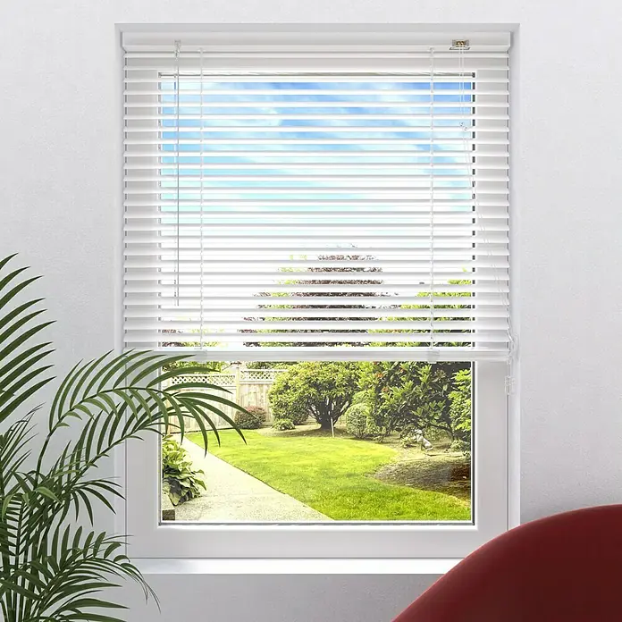 Expo Ambiente Jalousie II - B x H: 140 x 250 cm, Weiß, Aluminium - Ein Fenster mit weißen Jalousien, das einen Blick auf einen grünen Garten mit Bäumen und einem gepflasterten Weg bietet. Die Jalousien sind teilweise geöffnet.