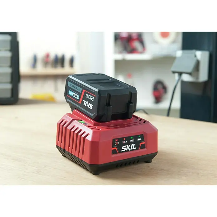 Skil PWRCore 20V Batería y cargador Energy Platform 3110 AA - 20 V, 1 batería, 2,5 Ah - El cargador de batería Skil de 20V con una batería de iones de litio de 20V sobre una superficie de madera clara, ideal para herramientas eléctricas.