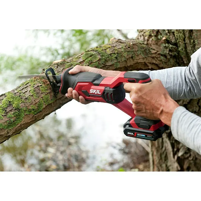 Skil PWRCore 20V Akku-Säbelsäge 3470 CA - 20 V, Ohne Akku, Leerlaufhubzahl: 0 /min - 3.000 /min - Eine rote SKIL Akku-Säbelsäge schneidet einen Ast. Ideal für Gartenarbeiten und Baumschnitt.