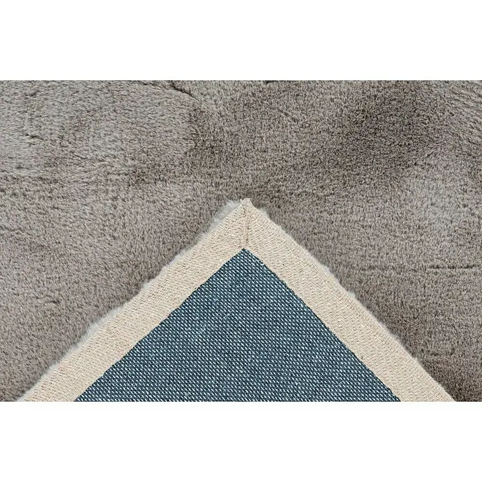 Fellteppich Happy - Taupe, 150 x 80 cm, 100 % Polyester (Flor) - Detailaufnahme eines grauen Teppichs, der seine Textur und Unterseite mit einem beigen Rand und blauem Gewebe zeigt.