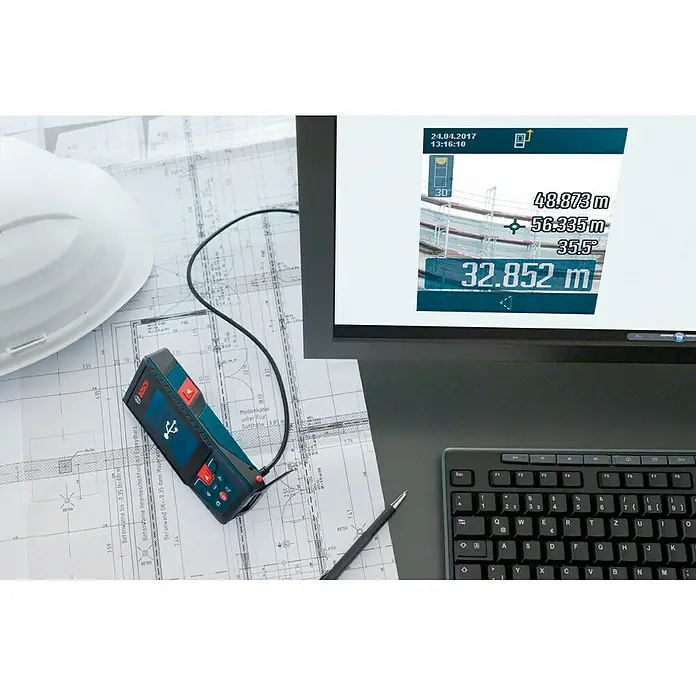 Bosch Professional Láser de línea GLL 3-80 CG - Zona de trabajo máx.: 30 m - Un medidor láser de distancia Bosch con conexión por cable a un monitor que muestra datos de medición, junto a planos y un casco.