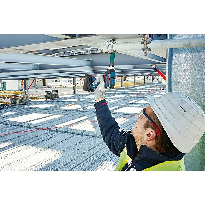 Bosch Professional AMPShare 18V Taladro atornillador de batería GDS 18 V-LI - 18 V, 2 baterías, 4 Ah, 300 Nm - Un trabajador de la construcción usa una llave de impacto inalámbrica Bosch para asegurar tuberías a una estructura de techo.