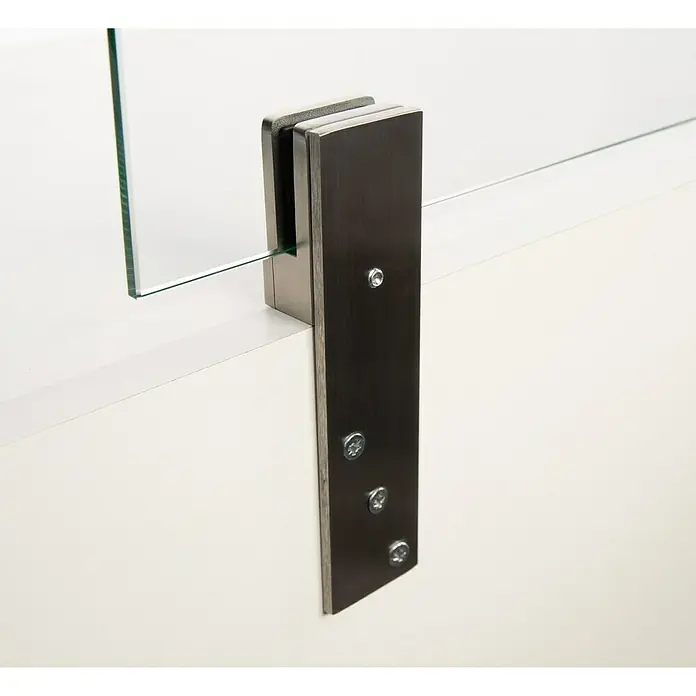 Room Plaza Thekenhalter - 139 x 40 mm, Edelstahl, Passend für: Room Plaza Hygieneschutzglas - Eine Nahaufnahme einer Glasscheibe, die mit einer Metallklammer an einer weißen Oberfläche befestigt ist. Die Halterung ist mit Schrauben fixiert.