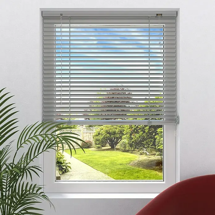 Expo Ambiente Jalousie II - B x H: 160 x 250 cm, Silber, Aluminium - Graue Jalousien vor einem Fenster mit Blick auf einen Garten. Die Jalousien sind geschlossen und verdecken teilweise die Aussicht.