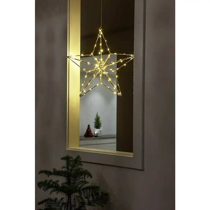 Konstsmide LED-Stern - Gold, Lichtfarbe: Warmweiß, IP20, Netzbetrieben - Ein sternförmiger LED-Draht-Hängeleuchter, der Wärme und festliche Stimmung verbreitet, hängt vor einem Fenster und strahlt ein sanftes Licht aus.