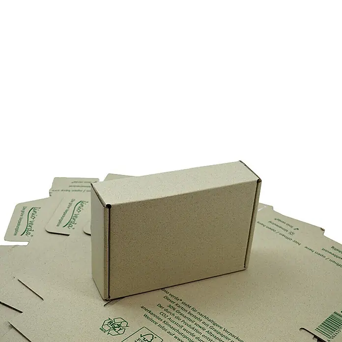 PackMann linio verda® Verpackungskarton - L x B x H: 230 x 160 x 60 mm - Nahaufnahme einer umweltfreundlichen, rechteckigen, beigen Kartonverpackung mit Text und Logos auf anderen Kartons.