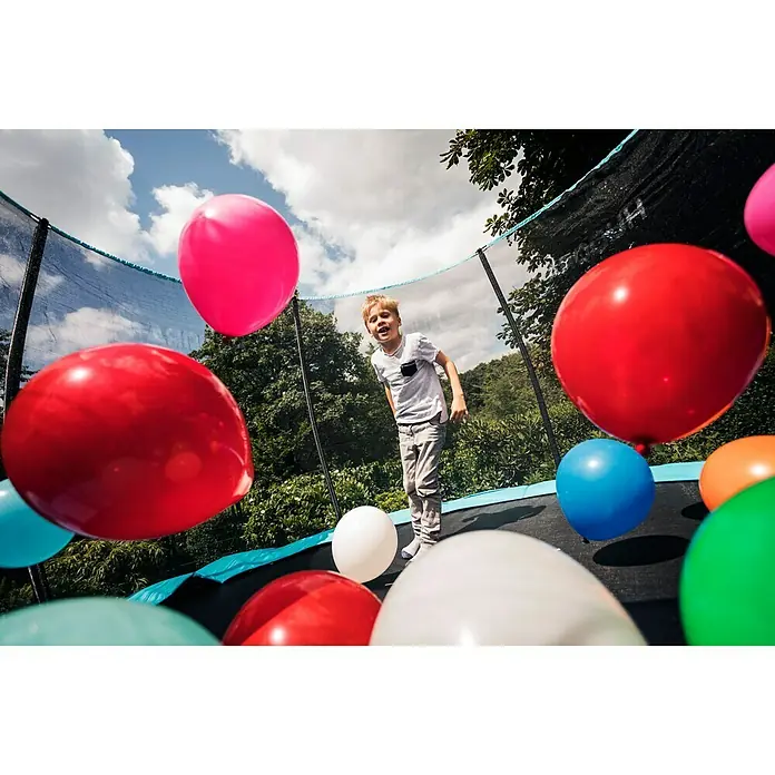 Hudora Trampolin Fantastic Complete 300 V - Durchmesser: 300 cm - Ein lachender Junge springt auf einem Trampolin, umgeben von bunten Ballons und dem Sicherheitsnetz, während er Spaß im Freien hat.