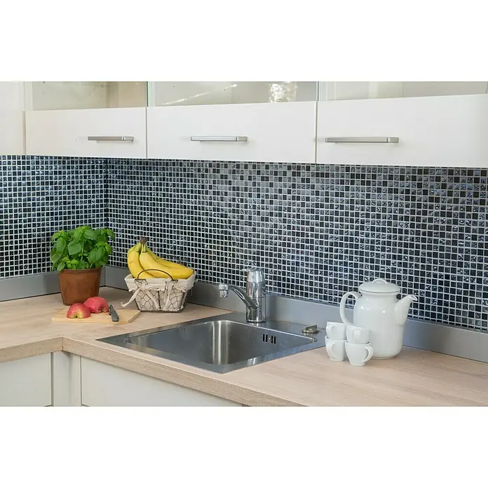 Mosaikfliese Quadrat Mix XCM M860 - 30,5 x 32,2 cm, Schwarz, Glänzend - Küchenspüle aus Edelstahl mit Armatur, umgeben von Geschirr und Lebensmitteln auf einer Arbeitsplatte mit Mosaikhintergrund.