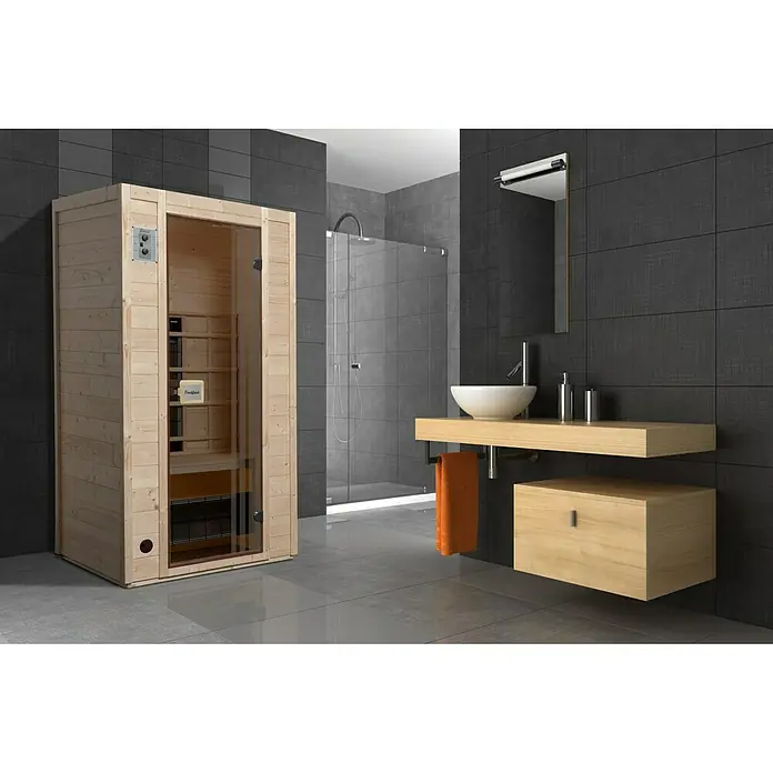 Finnwood Infrarotkabine Svea 1 by WEKA - 1.700 W, 4 Keramikstrahler, 100 x 102 x 196 cm - Innenaufnahme eines Badezimmers mit einer Holzsauna, einem Waschtisch mit Waschbecken und einer Dusche. Graue Fliesen dominieren das stilvolle Design.