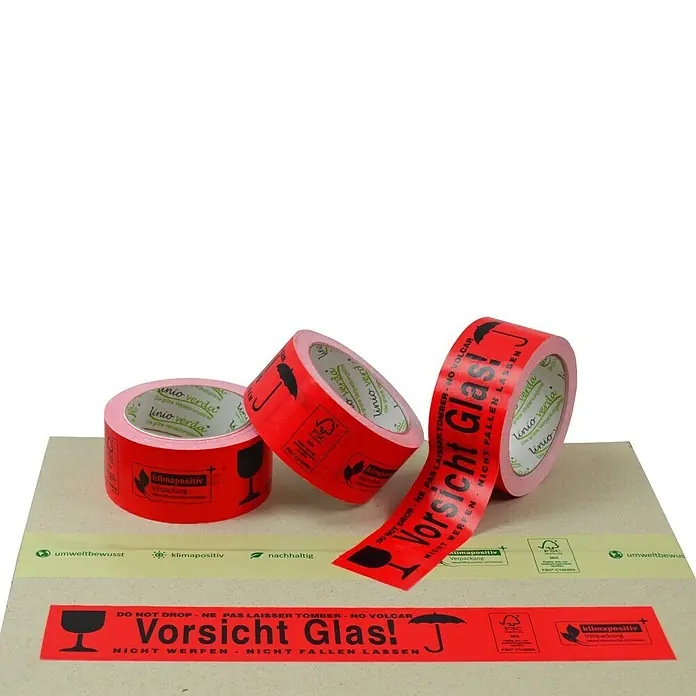 PackMann linio verda® Packband - Vorsicht Glas, L x B: 50 m x 50 mm - Drei Rollen rotes Packband "Vorsicht Glas!" auf einem Karton.