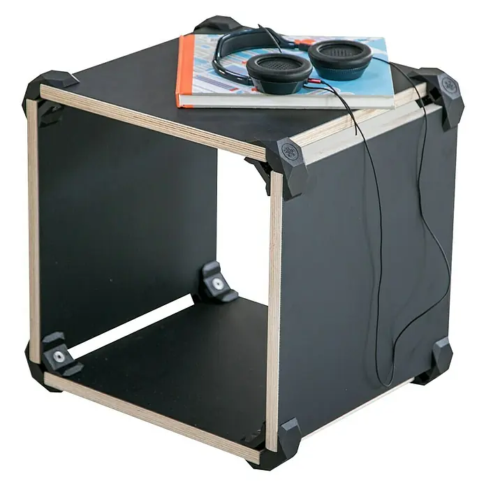 Playwood Sistema de unión - Ángulo: 90 °, Negro profundo, 4 ud. - La imagen muestra una estantería negra en forma de cubo con un libro y unos auriculares. Es un mueble moderno.
