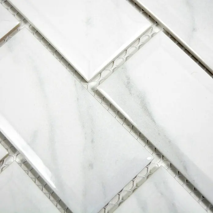 Mosaikfliese Metro Uni Calacatta CG MCT - 29,55 x 29,1 cm, Weiß, Glänzend - Nahaufnahme der eleganten weißen Marmorfliesen im Fischgrätmuster, ideal für stilvolle Wand- und Bodenbeläge.