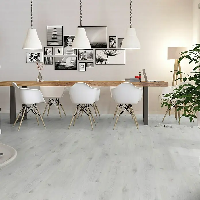 b!design Vinylboden Isocore Inside - Chamonix, Landhausdiele, 1.510 x 300 x 7 mm - Helle, moderne Esszimmergestaltung mit weißem Holzboden, umgeben von minimalistischen Möbeln und sanftem Tageslicht.
