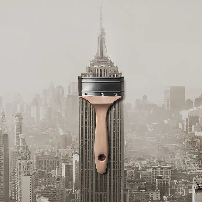 SCHÖNER WOHNEN-Farbe Wandfarbe Trendfarbe - Manhattan, Matt, 1 l, Konservierungsmittelfrei - Kreative Darstellung: Ein Pinsel überlagert das Empire State Building, symbolisch für künstlerische Gestaltung New Yorks.