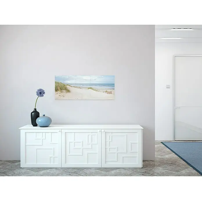 Glasbild - Seeblick IV, B x H: 125 x 50 cm - Wohnzimmer mit einem weißen Sideboard, einer Wanddekoration mit Strandmotiv und dekorativen Vasen. Elegante Raumgestaltung.