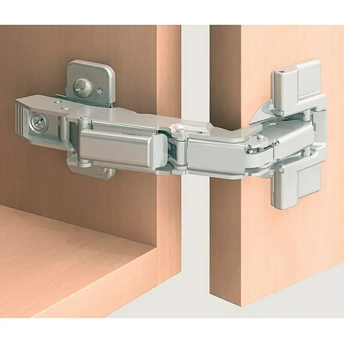 Stabilit Bisagra de ángulo ancho - Tipo de tope: Tope de esquina, Ángulo de apertura: 170 ° - Bisagra metálica de puerta de armario fijada a dos puertas de madera. La bisagra es plateada y de construcción compleja.