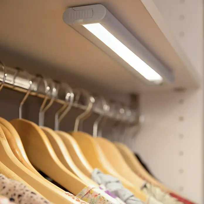 Ledvance LED-Unterbauleuchte Mobile - 1,9 W, Bewegungssensor, L x B x H: 21,4 x 4,8 x 1,8 cm, Weiß - Eine LED-Schrankleuchte beleuchtet Kleidung an Holzbügeln. Die Leuchte sorgt für Helligkeit im Kleiderschrank.