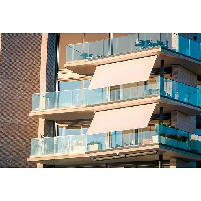 SmartSun Toldo para balcón Urban - Beige arena, Ancho: 2 m, Caída: 2,45 m - Los toldos beige dan sombra a los balcones de un moderno edificio de apartamentos con barandillas de cristal.