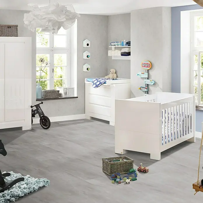 Vinylboden Strong SPC - Travertin Romano, Fliese, 935 x 465 x 6,5 mm - Elegantes Kinderzimmer mit weißem Kinderbett, Wickeltisch und Schrank. Helle, freundliche Atmosphäre mit Spielsachen auf dem Boden.