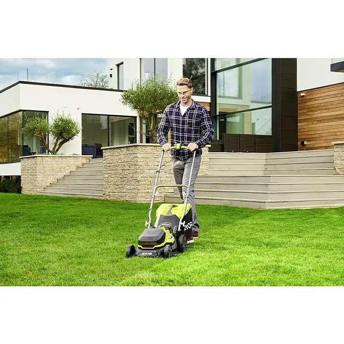 Ryobi ONE+ Akku-Rasenmäher RY18LM37A-240 - 18 V, 2 Akkus, 4 Ah, Schnittbreite: 37 cm - Ein Mann mäht Rasen mit einem Ryobi-Rasenmäher vor einem modernen Haus. Der Rasenmäher ist gelb und schwarz, und der Mann trägt eine Schutzbrille.