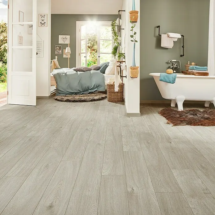 LOGOCLIC Laminatmuster Aquaprotect Nature Oak - 290 x 200 x 8 mm, Landhausdiele - Elegantes Interieur mit hellem Holzboden, offenem Schlafzimmer und angrenzendem Badezimmer mit freistehender Badewanne.