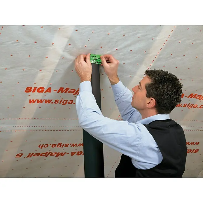 Siga Klebeband Rissan 60 - 25 m x 60 mm, Armierte Spezialfolie aus PE - Mann befestigt SIGA-Majpell Dichtungsbahn an einem Rohr mit SIGA-Dichtband für luftdichte Gebäudehülle.