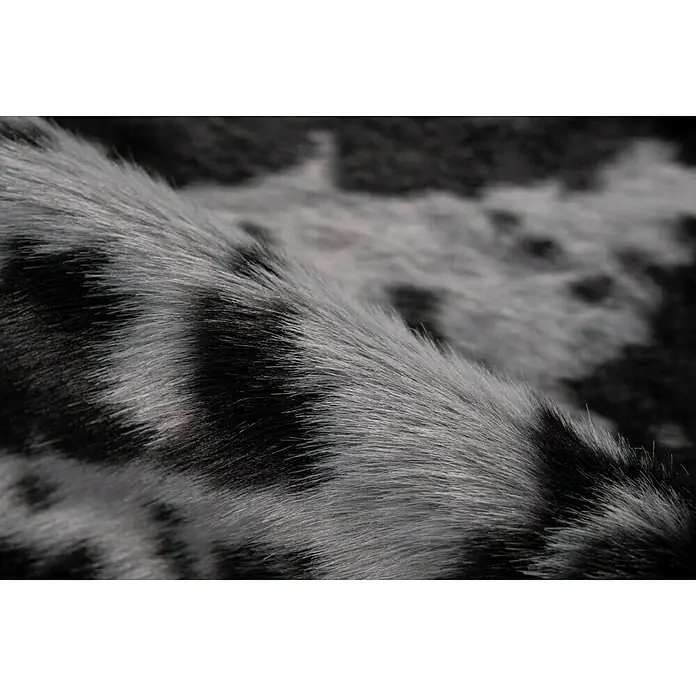 Kayoom Kunstfell Desert - Schwarz/Weiß, 230 x 160 cm, 85 % Acrylic, 15 % Polyester - Detailaufnahme eines grauen, gefleckten Fells, das Textur und Muster hervorhebt. Ideal für Mode oder Inneneinrichtungszwecke.