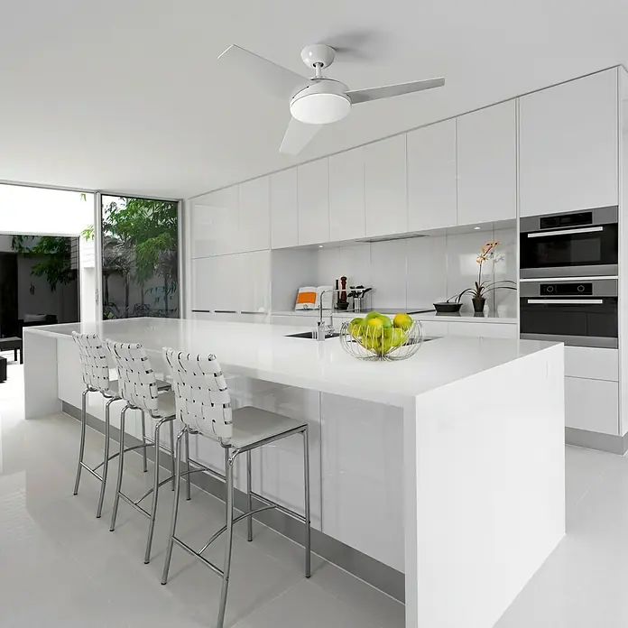 Forlight Ventilador de techo Windy - Blanco, 101,6 cm, 43 W - Una cocina moderna con isla, taburetes y un ventilador de techo blanco.
