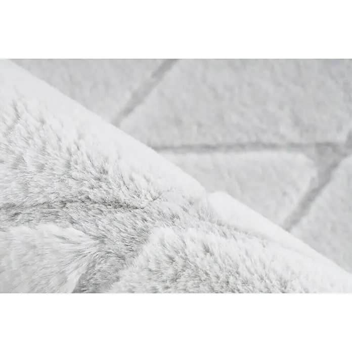 Kayoom Hochflorteppich Vivica 225 - Weiß/Blau, 230 x 160 cm - Detailaufnahme eines hellgrauen, hochflorigen Teppichs, der eine weiche und luxuriöse Textur zeigt. Ideal für Wohnräume, die Wärme und Komfort suchen.