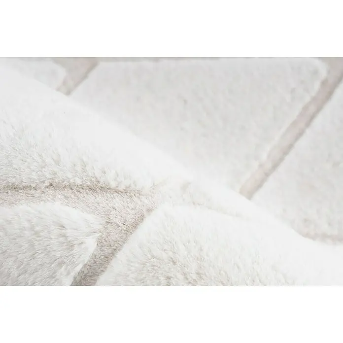 Kayoom Hochflorteppich Vivica 225 - Weiß/Creme, 230 x 160 cm - Nahaufnahme eines flauschigen, weißen Teppichs mit einem subtilen geometrischen Muster, das Komfort und Stil vereint.