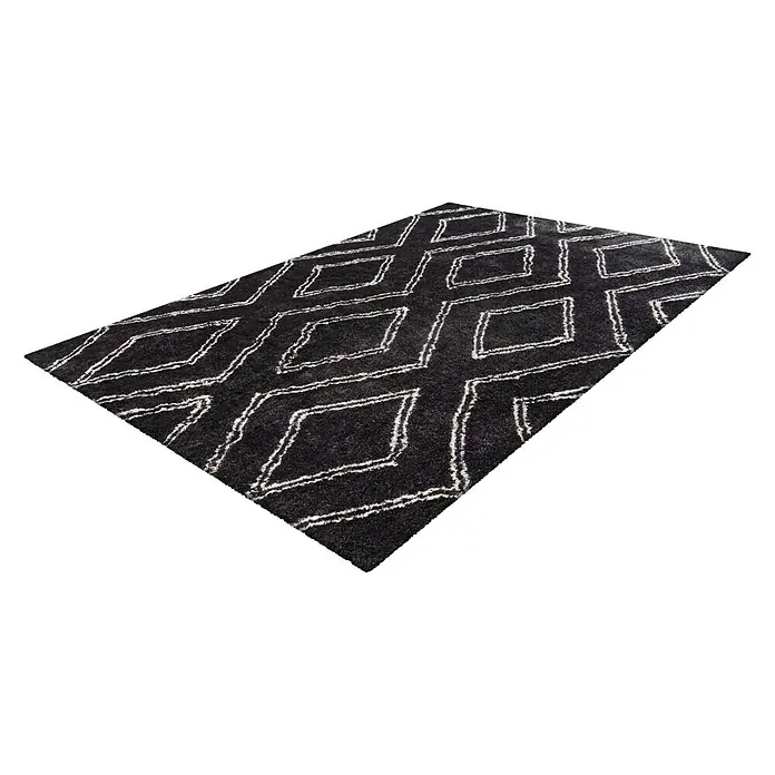 Kayoom Hochflorteppich Orlando 225Anthrazit, 290 x 200 cm, 100 % Polyester - Ein rechteckiger, schwarzer Teppich mit einem weißen Rautenmuster. Der Teppich liegt schräg auf einem weißen Hintergrund.