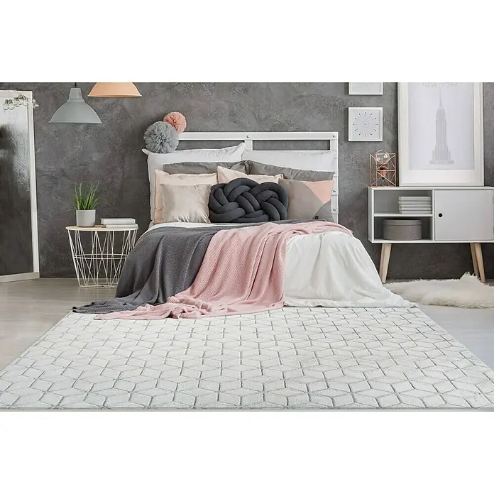 Kayoom Hochflorteppich Vivica 125 - Weiß/Anthrazit, 150 x 80 cm - Ein modernes Schlafzimmer mit einem hellen Teppich mit geometrischem Muster. Der Teppich dominiert den Raum und sorgt für einen stilvollen Akzent.