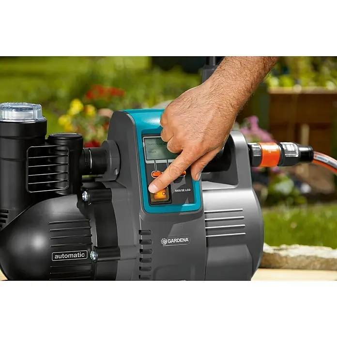 Gardena Hauswasserautomat 5000/5 LCD - 1.300 W, 5.000 l/h, 5 bar - Nahaufnahme der Gardena 5000/5E LCD Hauswasserautomat mit einer Hand, die das Display berührt.