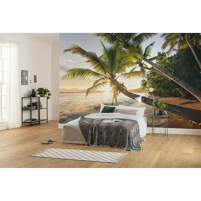 Komar Stefan Hefele Edition 2 Fototapete Strandgeheimnis - 9 -tlg., B x H: 450 x 280 cm, Vlies - Ein Schlafzimmer mit einem Bett vor einer Wandtapete mit einem tropischen Strandmotiv und einer stilvollen Einrichtung.