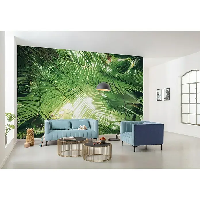 Komar Stefan Hefele Edition 2 Fototapete Dschungeldach - 9 -tlg., B x H: 450 x 280 cm, Vlies - Ein modernes Wohnzimmer mit blauen Möbeln, goldenen Tischen und einer Wand mit tropischen Pflanzen für eine entspannte Atmosphäre.