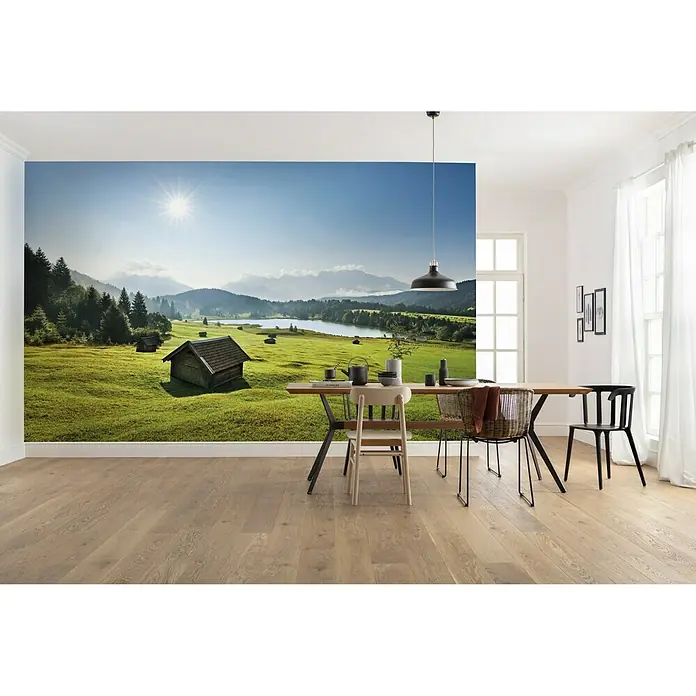 Komar Stefan Hefele Edition 2 Fototapete Bergwiese vor Karwendel - 9 -tlg., B x H: 450 x 280 cm, Vlies - Ein helles Esszimmer mit einem Esstisch und Stühlen vor einer großen Fototapete mit Berglandschaft.