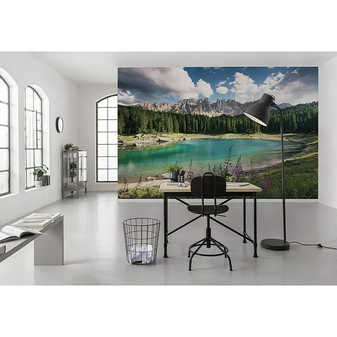 Komar Stefan Hefele Edition 2 Fototapete Dolomiten Juwel - 9 -tlg., B x H: 450 x 280 cm, Vlies - Ein moderner Arbeitsbereich mit einer Fototapete, die eine ruhige Bergseeszene zeigt, ergänzt durch minimalistische Möbel und eine Stehlampe.
