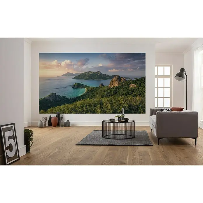 Komar Stefan Hefele Edition 2 Fototapete Monkey Island - 7 -tlg., B x H: 350 x 200 cm, Vlies - Wohnzimmer mit einer Wandtapete, die eine Insellandschaft zeigt, mit einem Sofa und einem Couchtisch.