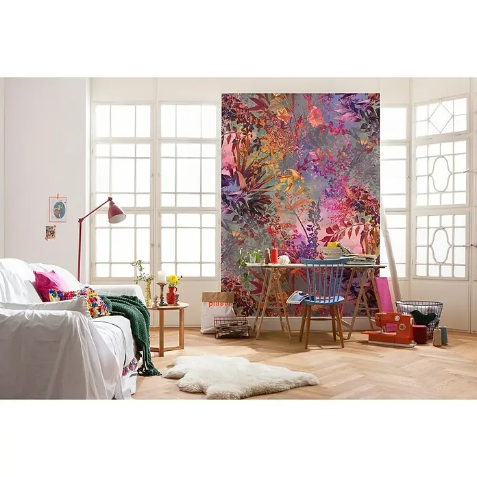 Komar Imagine Edition 3 - Stories Fototapete Wild Garden - 4 -tlg., B x H: 184 x 254 cm, Papier - Ein farbenfrohes Wohnzimmer mit floraler Tapete, hellem Sofa und einem Holztisch mit blauem Stuhl. Die Dekoration ist verspielt und einladend.