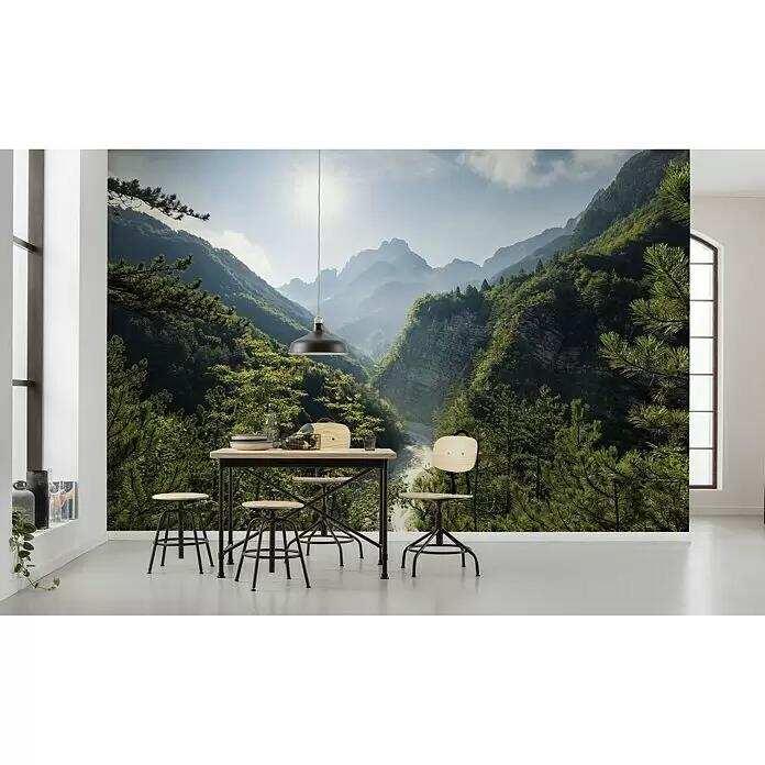 Komar Stefan Hefele Edition 2 Fototapete Elbenpforte - 9 -tlg., B x H: 450 x 280 cm, Vlies - Wandbild einer lebhaften grünen Berglandschaft mit Fluss unter hellem Himmel, in einem modernen Essbereich.