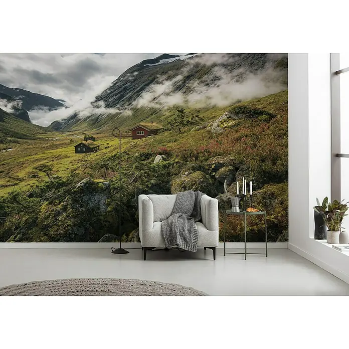 Komar Stefan Hefele Edition 2 Fototapete Pure Norway - 9 -tlg., B x H: 450 x 280 cm, Vlies - Gemütliches Interieur mit Sessel, Beistelltisch und einer eindrucksvollen Fototapete einer norwegischen Berglandschaft, die eine entspannende Atmosphäre schafft.