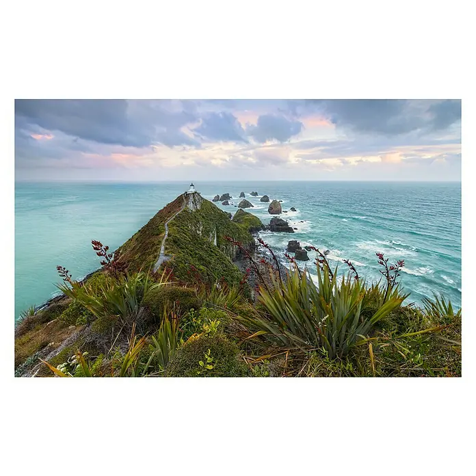 Komar Stefan Hefele Edition 2 Fototapete The Nuggets - 9 -tlg., B x H: 450 x 280 cm, Vlies - Naturaufnahme mit Blick auf einen Leuchtturm an der Küste, umgeben von üppiger Vegetation unter einem bewölkten Himmel.