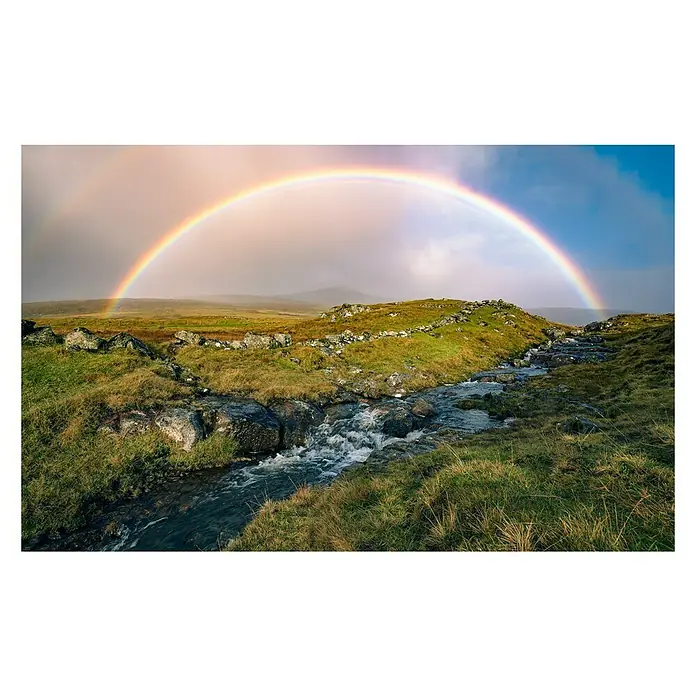 Komar Stefan Hefele Edition 2 Fototapete Coloured Faeroer - 9 -tlg., B x H: 450 x 280 cm, Vlies - Naturszene mit einem lebendigen Regenbogen über einer grünen Landschaft mit einem Bach, der durch Felsen fließt.