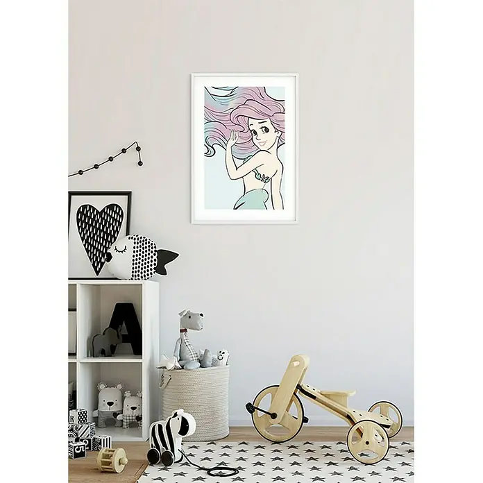 Komar Disney Edition 4 Poster Ariel Aquarell - Disney, B x H: 50 x 70 cm - Ein gerahmtes Wandbild von Arielle, der Meerjungfrau, hängt in einem Kinderzimmer, das mit Spielzeug dekoriert ist.