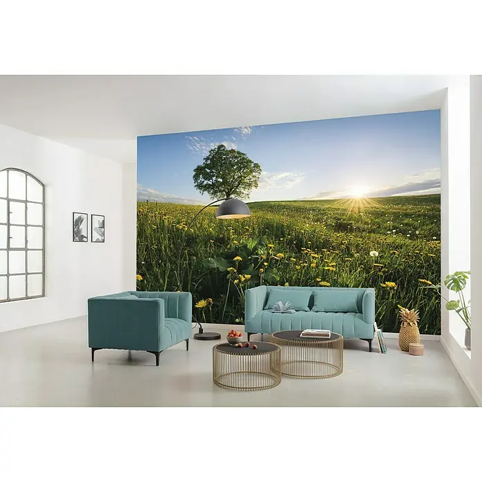 Komar Stefan Hefele Edition 2 Fototapete Frühling auf dem Land - 9 -tlg., B x H: 450 x 280 cm, Vlies - Einladender Raum mit einem hellblauen Sofa, einem Sessel, goldenen Tischen und einer Wandtapete mit einer grünen Wiese und einem Baum.