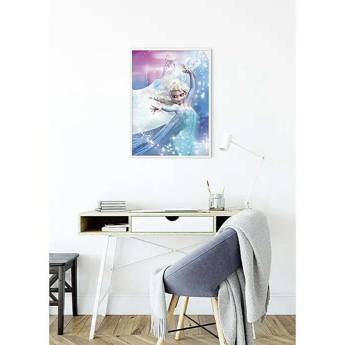 Komar Disney Edition 4 Poster Frozen Elsa Action - Disney, B x H: 40 x 50 cm - Ein gerahmtes Frozen-Poster mit Elsa an einer weißen Wand über einem Schreibtisch mit Lampe und Stuhl.